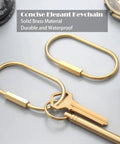 Ten Piece Solid Gold Brass Key Rings Set With Locking Carabiner Clips And Screw Lock Oval Keychains Durable Purse Bag Charms Holder For Handbags And Everyday Carry On The Go, showing oval keychain with attached key on a surface.