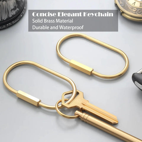 Ten Piece Solid Gold Brass Key Rings Set With Locking Carabiner Clips And Screw Lock Oval Keychains Durable Purse Bag Charms Holder For Handbags And Everyday Carry On The Go, showing oval keychain with attached key on a surface.