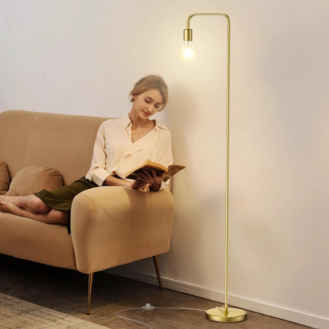 Industrial Floor Lamp With Light Bulb Included, tall standing light in brushed gold next to a woman reading on a beige sofa