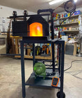 Electric Blacksmith Forge Blower 110V 250W for Coal Fires in workshop setup, showing lit forge and blower unit.