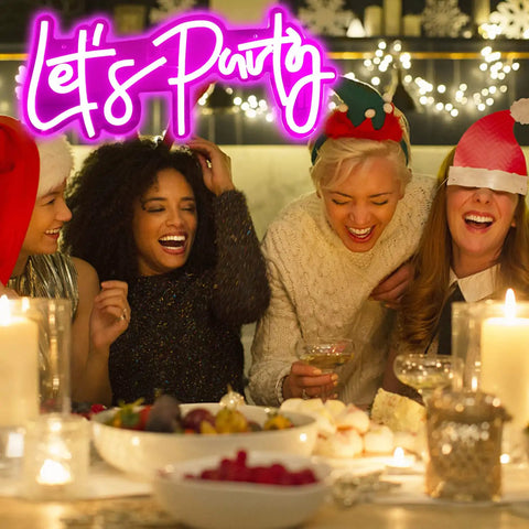 Friends laughing at a festive gathering with a 'Let's Party' neon sign lit up in the background