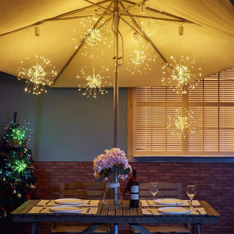 Lit 4 Pack Firework LED Copper Wire Star String Lights With Remote hanging under patio umbrella for wedding decor
