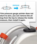 Close-up of a stainless steel pressure vessel lid with a black cap and orange locking clamps