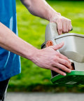 Person using No Crank One Touch Battery Powered Spreader For Fertilizer Seed And Ice Handheld Spreader With EdgeGuard Tech.