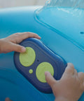 Toddler hands on remote of Remote Control Baby Pool Float With Enclosed Propeller Guard, Motorized Toddler Boat For Ages 1 To 4