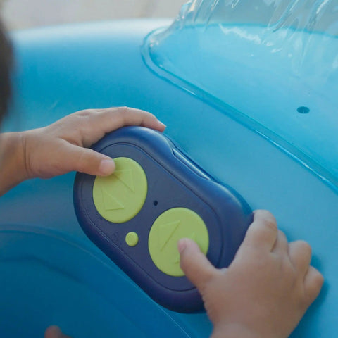Toddler hands on remote of Remote Control Baby Pool Float With Enclosed Propeller Guard, Motorized Toddler Boat For Ages 1 To 4