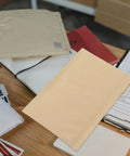 Premium Kraft Bubble Mailers Set Of 20 22x34cm Thick Padded Self Sealing Shockproof Shipping Envelopes on desk with paperwork and notebook