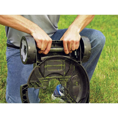 Person attaching removable deck to 12-inch trimmer, converting it into a mower, showcasing two height settings on grass field