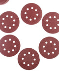 Super Tough 5 Inch Hook And Loop Sanding Discs With Eight Holes For Dustless Vibes arranged on a flat surface, showing fine alumina grain.