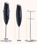 Game Changing Handheld Milk Frother Wand Battery Operated Stainless Steel Drink Mixer For Milk Coffee Lattes Cappuccino Frappe Matcha Hot Chocolate With Stand Gift, showing side and front view with stand
