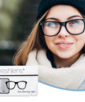 Freshlens lens cleaning wipe packet in foreground; woman wearing black-framed glasses (front view).