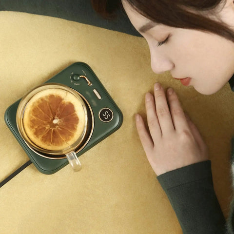 Smart Home Cup Warmer Heating Plate With Smart Temp Control Keeps Your Daily Sips Locked And Toasty Auto Shutoff Safety Feature 25 Watt Energy Savers Green Coaster Drink Heater For Coffee And Milk Tea on a desk with a glass mug.
