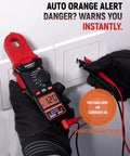Round Jaw Digital Clamp Meter With NCV And 2000 Counts in use, displays 120V, gloved hands holding, auto orange alert active