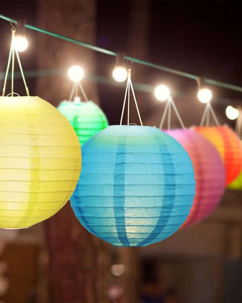 Multicolor 48 Pack Paper Lanterns For Parties Round Chinese Style Hanging Lamps In 4, 6, 8, And 10 Inch Sizes Easy To Fold And Store Durable Party Decor For Graduation Wedding Birthday Bridal Shower And Other Celebrations hanging at night, close-up view.