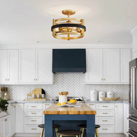 Modern kitchen with a gold and black drum ceiling light, white cabinetry, herringbone backsplash, and wooden island with stools.