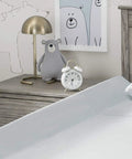 Bedroom with wooden headboard and nightstand, featuring bear-themed decor and a clock, ideal for using the Extra Long Foam Bed Rail For Toddlers And Kids, Water Resistant, Non Slip Guard With Machine Washable Cover, 1 Pack, White, Keeps Little Sleepers Safe From Rolling Out Of Bed, Portable Easy Unroll Design, Cozy Bedtime Shield.