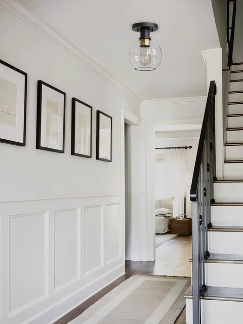 Modern Farmhouse 1 Light Flush Mount Ceiling Light with Clear Glass Globe in black and gold finish in a stylish hallway.
