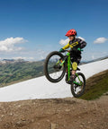 Kid performs a wheelie on a mountain bike, showcasing Speedrun Junior Mountain Bike Handlebar With Bar Clamp 31.8mm, 680mm Width.