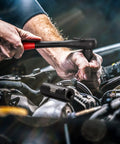 Mechanic using Half Inch Drive Master Impact Socket Set For Heavy Duty Wrenching on car engine, showing hand and tool detail.