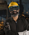 Built Like A Tank Welding Safety Goggles on man with yellow hard hat, showing serious protection in workshop environment.