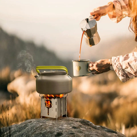 All Fuel Stainless Steel Camping Stove For Solo Campers Folding Backpacking Stove with kettle, outdoor cooking setup on rock
