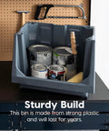 Six Pack Dark Gray Open Front Storage Totes With Oversized Handles Built Like A Tank Heavy Duty Stackable Plastic Bins Mega Capacity For Garage Gear And Home Drop Zones Shed Interlocking Top Shelf Design filled with paint cans on a work surface.