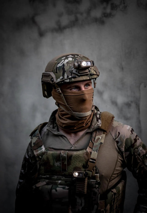 Soldier wearing helmet with Sidewinder 55 Lumen Compact II Military Flashlight, hands free lighting ready.