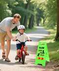 Bright green Three Pack Kids Playing Signs For Street Reflective Slow Down Alert Sign on sidewalk near child riding bike