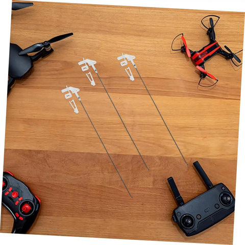 Three 20 sets fixed wing airplane control horns pushrods and linkage stoppers kit on table with drones and controllers nearby.