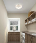 Meridian 3 Light Ceiling Mount Fixture In Brushed Nickel With Oatmeal Fabric Drum Shade illuminating a modern laundry room.