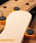 Rock Solid Workbench Clamp Set For Woodworking Holds Your Boards Tight Includes Two 8 Inch Hold Fast Two Three Quarter Inch Square Clamps And Four Deluxe Bench Dogs For Pro Shop Setup, showing orange bench dogs securing a board.