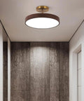 Japanese Style Led Close To Ceiling Light Fixture With Imitation Wood Grain Texture And Sleek Metal Ring illuminated in modern hallway.