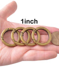 4 Pack Round Carabiner Key Rings With Spring Snap Clips And Flat O Rings In Brushed Brass Finish on palm, size comparison to coin