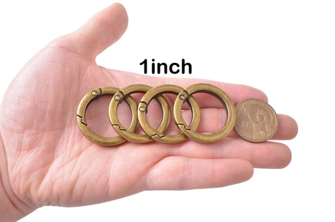 4 Pack Round Carabiner Key Rings With Spring Snap Clips And Flat O Rings In Brushed Brass Finish on palm, size comparison to coin