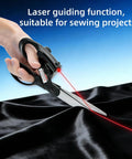 Hand using Laser Guided Fabric Scissors With Built In Red Laser Guide For Pro Level Precision Cuts In DIY Crafts on black fabric