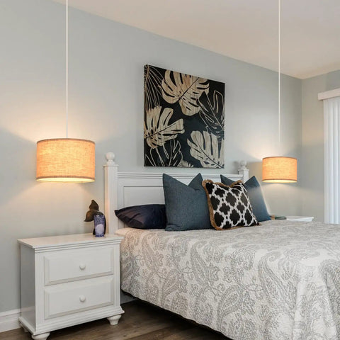 2 Pack Plug In Pendant Lights With 15Ft Clear Cord Toggle Switch Beige Linen Shade Modern Hanging Lamp over a styled bedroom.
