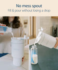 User pouring milk from a bottle into a Vacuum Insulated Stainless Steel Baby Formula And Breast Milk Chiller Tumbler With Cooling Insert.