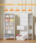 White Tall Dresser With Vertical Storage Tower And End Table Featuring Six Fabric Drawers And Drawer Organizer For Bedroom Living Room Closet Entryway Built Tough With Reinforced Metal Frame next to a vertical storage unit with books and toys.