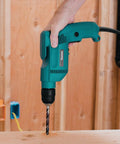 Powerful 4.9 Amp 3/8 Inch Drill With Variable Speed 0-2500 RPM Keyless Chuck Large Trigger Teal Finish in action on wood