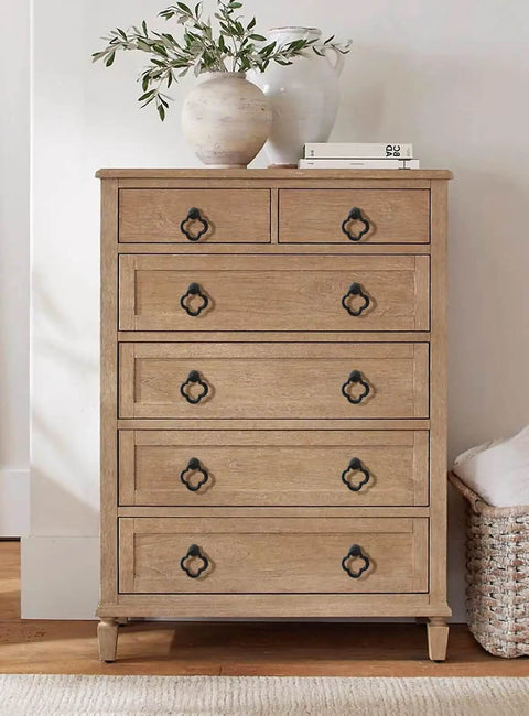 Wooden dresser with metallic handles, topped with pottery and books, featuring Gold Zinc Alloy Cabinet Knobs For Kitchen And Bathroom.