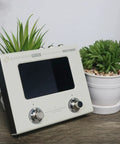 Ampero Mini MP50VN Guitar Multi Effects Processor With Touch Screen Modeling IR Cabinets shown on a table with potted plants.