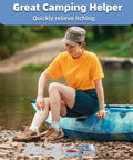Small portable first-aid kit on rocky lakeshore beside a blue canoe, with scattered medical supplies