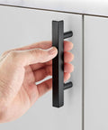 Hand holding 5 Inch Black Cabinet Handles Square Pulls Stainless Steel Drawer Pulls 3 Inch Hole Center Built To Last Tough Durable Kitchen Cabinet Hardware Set 40 Pack for Easy Install and Long Lasting Finish on gray cabinet