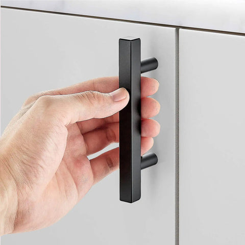 Hand holding 5 Inch Black Cabinet Handles Square Pulls Stainless Steel Drawer Pulls 3 Inch Hole Center Built To Last Tough Durable Kitchen Cabinet Hardware Set 40 Pack for Easy Install and Long Lasting Finish on gray cabinet