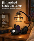 Jiji Black Cat Night Light Inspired by Kiki's Delivery Service on desk, cozy resin lamp with purple ears, warm glow, Studio Ghibli vibe