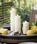 Outdoor Slim Pillar Flameless Led Candles Set Of 3 Ivory With Moving Flame Weather Resistant Remote Timer on a patio table with lemons.