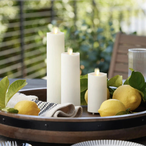 Outdoor Slim Pillar Flameless Led Candles Set Of 3 Ivory With Moving Flame Weather Resistant Remote Timer on a patio table with lemons.
