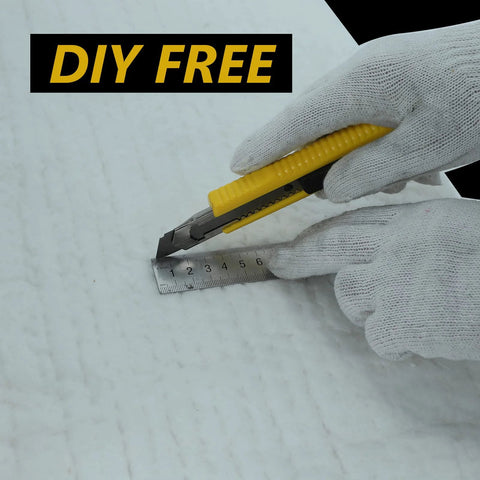 Utility knife with yellow handle held by gloved hands beside a metal ruler on a white work surface.