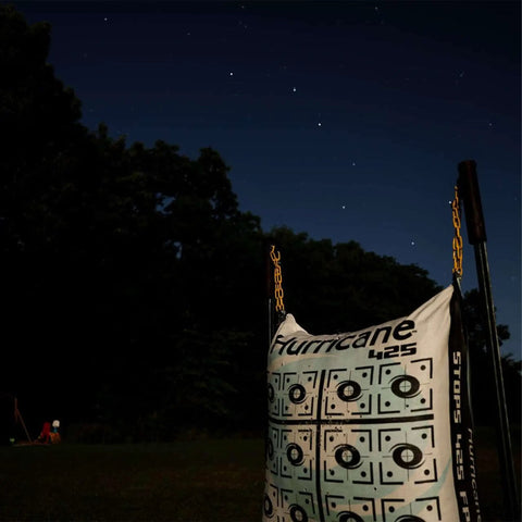Two Sided Archery Bag Target Built For 425 FPS Practice with bright high visibility aiming points under night sky, heavy duty handle