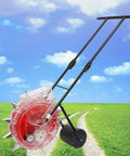 Metal Precision Garden Push Seeder With Clear Seed Storage Box Walk Behind Row Crop Planter in a grassy field